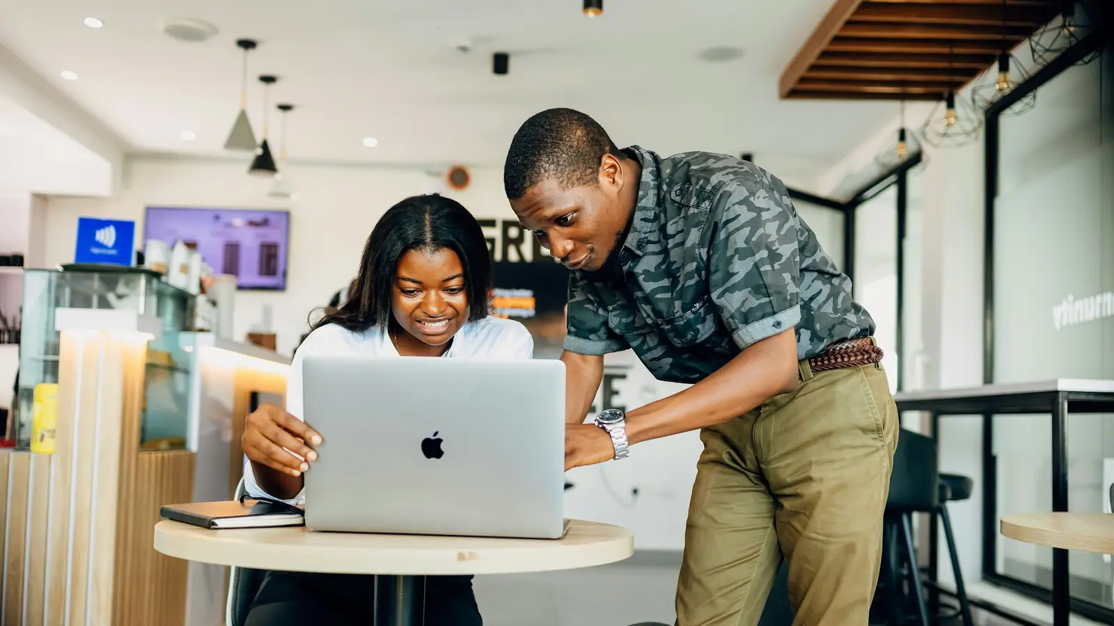 Two Nigerian professionals working together at a laptop